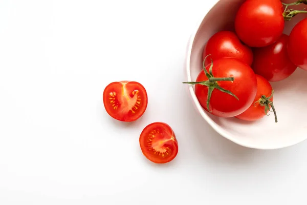 Tomates cherry frescos en un bol blanco sobre un fondo blanco. Concepto de alimentos crudos y vegetalesConcepto de alimentos crudos y vegetales — Foto de Stock