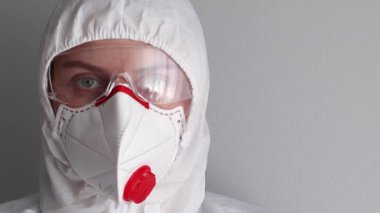 Coronavirus, hastalıklar, enfeksiyon, karantina, tıbbi maske korunması için tıbbi maske, gözlük ve koruyucu beyaz eşofman giyen bir sağlık memurunun portresi.