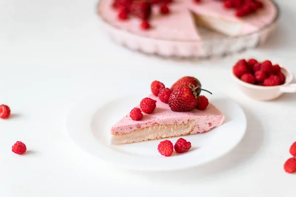 Домашний чизкейк с малиновым десертом на белой тарелке на столе — стоковое фото