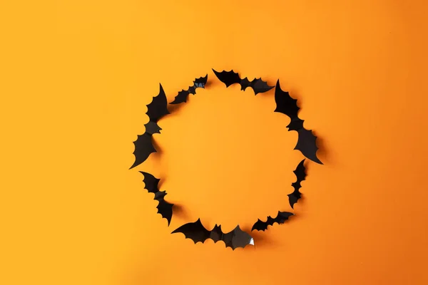 黑纸蝙蝠之间的秋天光晕在橙色的背景上飞舞 — 图库照片