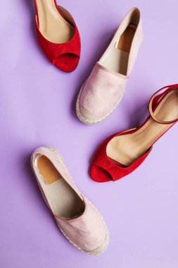 Eflatun arka planda yaz ayakkabıları. İndirimli ayakkabı konsepti