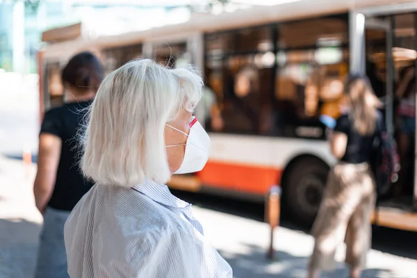 Mujer caucásica con máscara de protección contra el nuevo coronavirus 2019-ncov en la estación de tren pública, concepto de salud. — Foto de Stock