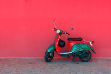 Elektrikli kırmızı yeşil scooter bir şehir caddesinde park ediyor. Araba paylaşım kavramı
