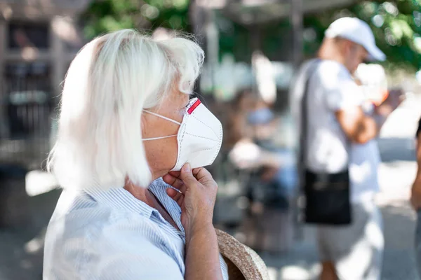 Fehér szőke nő védőmaszkot visel az új 2019-es ncov koronavírus ellen egy nyilvános vasútállomáson, egészségügyi koncepció. — Stock Fotó