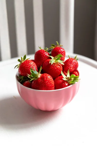 분홍색 배경에 딸기가 있는 찬장입니다. Summer composition, vertical photo — 스톡 사진