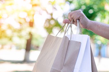 Kadın teslimat kuryesi, müşteriye göndermek için poşet dolusu erzak taşıyor..