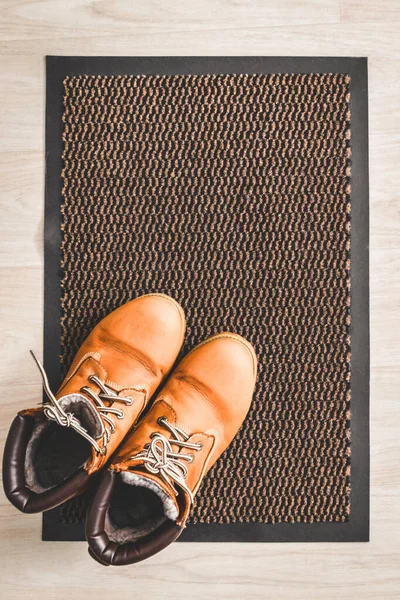女用棕色羊皮皮鞋放在走廊地板上的地毯上 — 图库照片