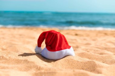 Tropik deniz sahilinde Noel Baba şapkası. Noel plajı tatil afişi ya da kartı