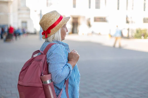 Turista mujer viajera en ropa casual azul, sombrero con mochila turística. Un pasajero que viaja al extranjero para un viaje de fin de semana. Concepto de viaje — Foto de Stock
