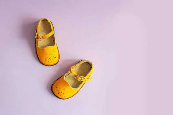 Sapatos Bebê Amarelo Brilhante Fundo Lilás Com Copyspace Conceito Roupa — Fotografia de Stock