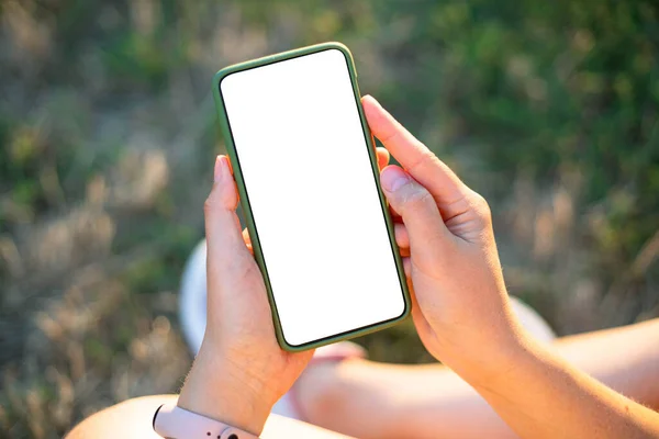 Perangkat smartphone Trendy mock up. Gadis hipster muda memegang ponsel dengan layar kosong dengan ruang fotokopi untuk desain atau logo di luar ruangan, cuaca cerah — Stok Foto