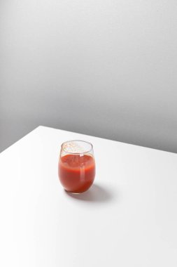 Masanın üzerinde bir bardak domates suyu bulunan en az yaratıcı kompozisyon. Sanat geometrik kavramı