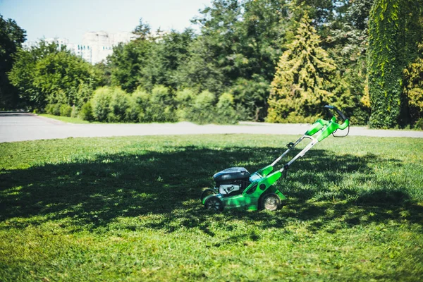 Cortador de grama elétrico em um gramado no jardim. — Fotografia de Stock