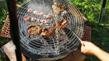 Biftek ve kebaplı ızgaranın kapanışı sıcak mangal kömürü üzerinde pişiyor. Yaz pikniği, açık hava yemekleri ve aile toplantısı kavramı. Lezzetli ızgara yiyeceklerin sembolü, tatil
