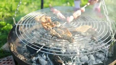 Biftek ve kebaplı ızgaranın kapanışı sıcak mangal kömürü üzerinde pişiyor. Yaz pikniği, açık hava yemekleri ve aile toplantısı kavramı. Lezzetli ızgara yiyeceklerin sembolü, tatil