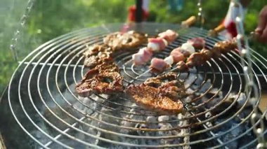 Biftek ve kebaplı ızgaranın kapanışı sıcak mangal kömürü üzerinde pişiyor. Yaz pikniği, açık hava yemekleri ve aile toplantısı kavramı. Lezzetli ızgara yiyeceklerin sembolü, tatil