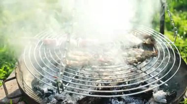 Biftek ve kebaplı ızgaranın kapanışı sıcak mangal kömürü üzerinde pişiyor. Yaz pikniği, açık hava yemekleri ve aile toplantısı kavramı. Lezzetli ızgara yiyeceklerin sembolü, tatil