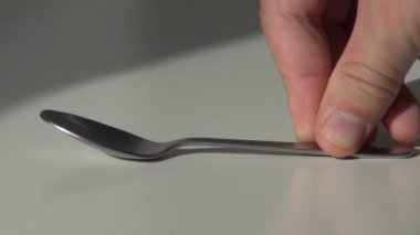 el bir çay kaşığı masanın üzerine koyar ve alır