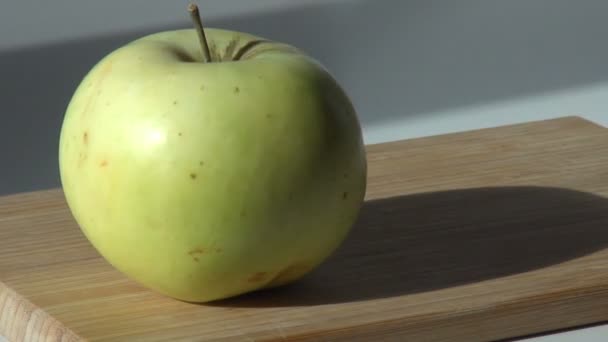 Groene appel is gezet op een houten snijplank en genomen — Stockvideo