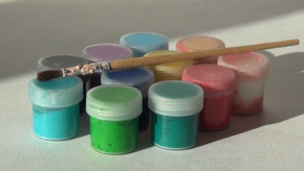 Kunstenaar zet en neemt een borstel met potten van acryl gouache-verf — Stockvideo