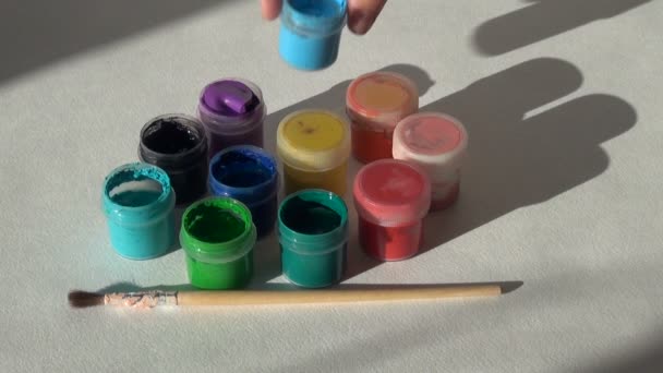 Artista abre frascos de pintura acrílica gouache — Vídeo de stock