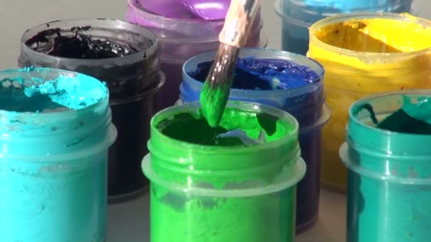 Pinceau immergé dans un pot de peinture gouache acrylique vert clair — Video