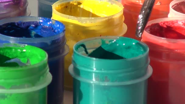 Pinceau immergé dans un bocal de peinture gouache acrylique verte. Travail à domicile — Video