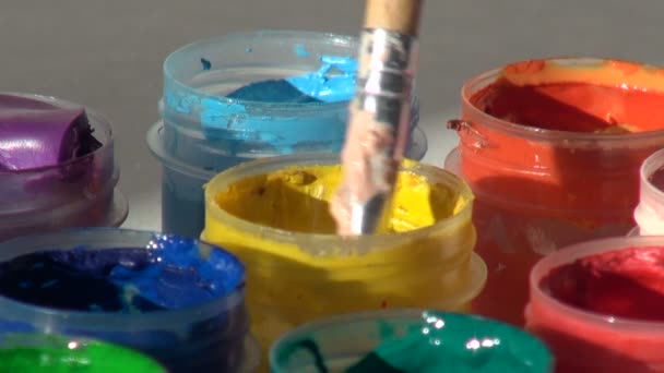 Brush immersed in a jar of yellow Acrylic gouache paint. Homewor — Stock Video
