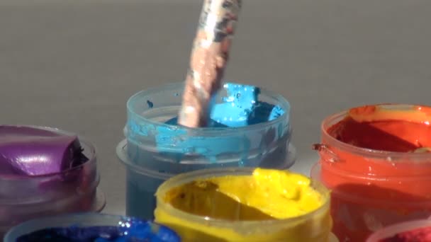 Brush immersed in a jar of blue cyan Acrylic gouache paint. Home — Stock Video