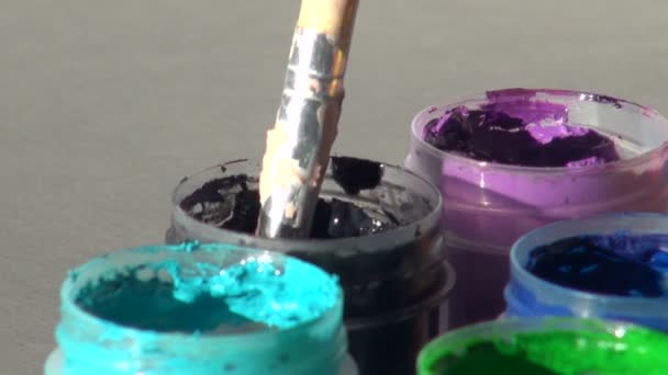 Brush immersed in a jar of black dark Acrylic gouache paint. Hom — Stock Video