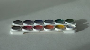 sanatçı boya ile masada çalışıyor.