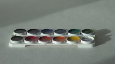 sanatçı boya ile masada çalışıyor.