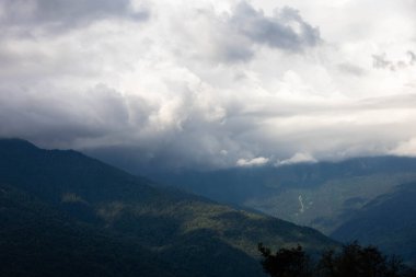 Dağlarda akşam bulutları. Yazın yeşil orman.