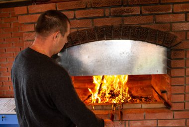 Adam ateşte barbekü hazırlıyor.