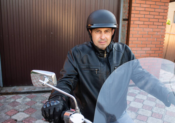 motorcyclist wearing a helmet, a black jacket on a motorcycle choppers