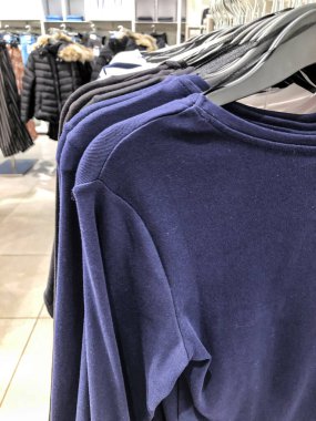 Mağazadaki askıda kadın kıyafetleri - paltolar, ceketler, bluzlar