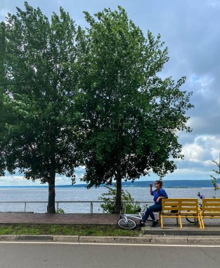Bir bankta spor yaptıktan sonra dinlenen bisikletli bir kızın fotoğrafı.