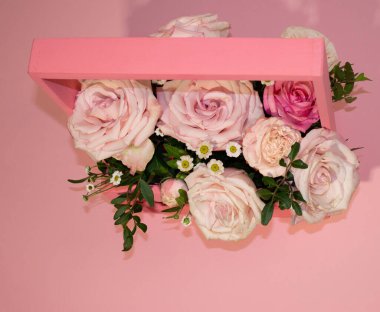 Kartpostal şablonu, kopya sprey pembe arka plandaki sepetteki pembe güller.