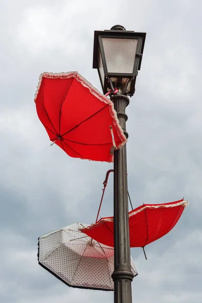 街路灯でぶら下がっているカラフルな雨傘 — ストック写真