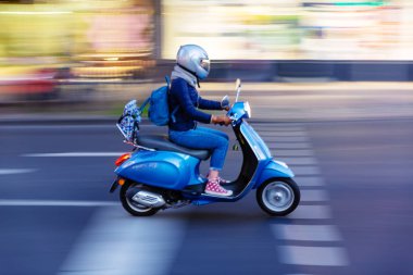bir scooter üzerinde hareket ile şehir hareketle genç kadınla bulanıklık etkisi