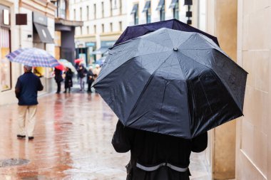 insan yağmurlu bir günde bir alışveriş caddesi şemsiyelerle resim