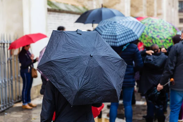 crowds of people with umbrellas on the move in the city