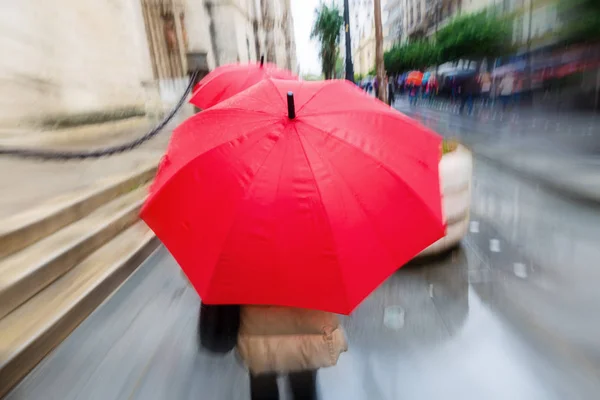 カメラで雨の多い街で赤い傘の人作ったズーム効果 — ストック写真