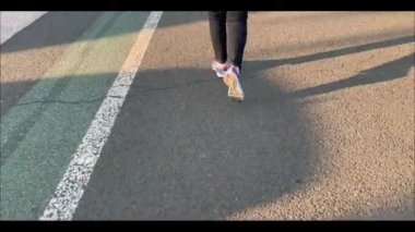  Ayaklar spor ayakkabılarında asfalt yolda