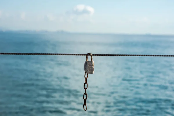 南京錠は海を背景にロープに固定されています — ストック写真