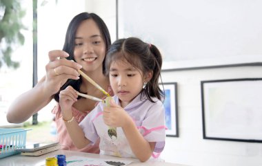 Asya Anne ve kızı boyama sulu boya resim nesnesi yaratıcı faaliyetleri yapmak için.