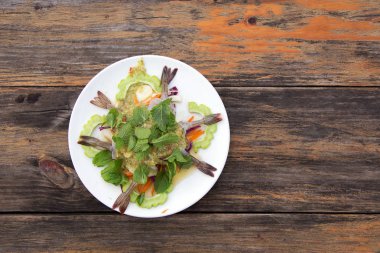 çiğ karides deniz ürünleri ile biber sosu, nane yaprağı ve sebze üst görünümden ahşap masa üzerinde hizmet