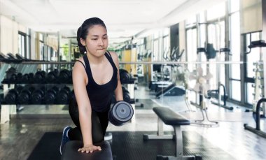Spor salonunda dambılı olan sağlıklı Asyalı bir kadın.