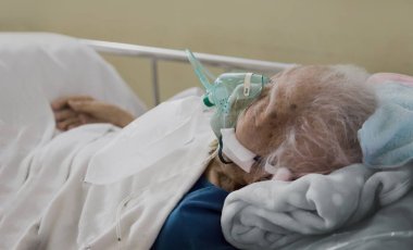 Emekli bir kadının eski bir hastasının kalp atış hızı ekipmanı ve maskesiyle hastanede yatmasının son nefesine kadar iyileşme süreci.