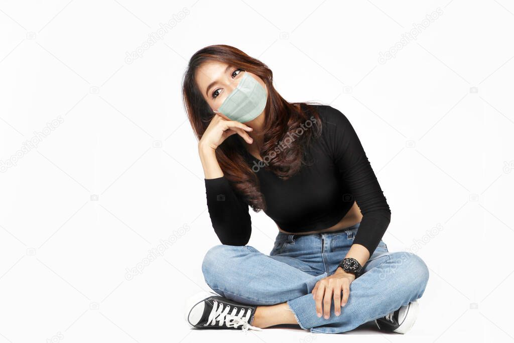 asian woman wearing face mask with casual dress on white isolated background in coronavirus pandemic still having expand in waiting for medicine to healing good health
